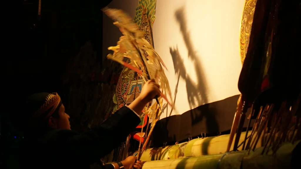 A dalang performing Wayang Kulit with traditional leather puppets and a gamelan orchestra in Indonesia.