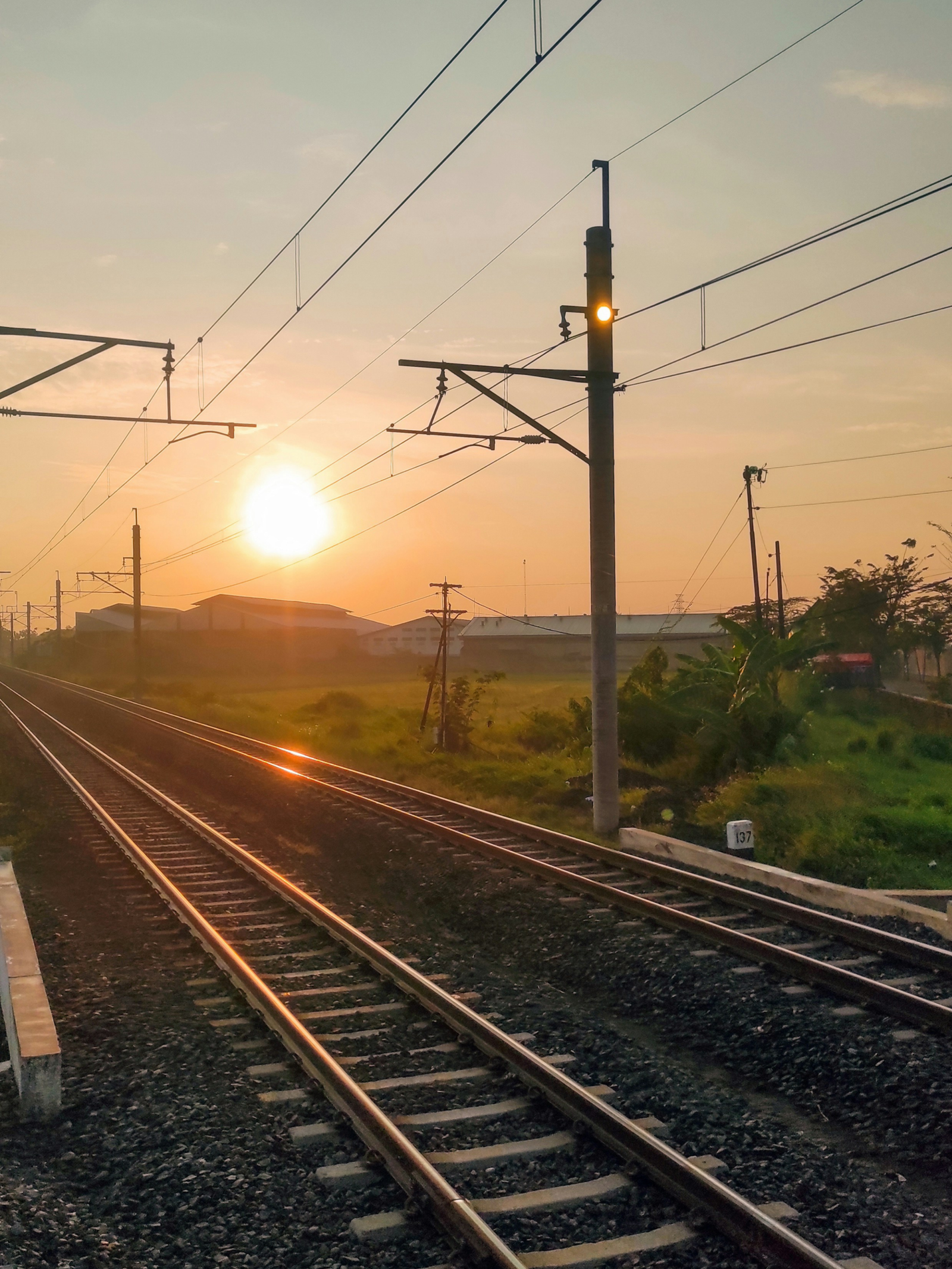 Railway tracks at sunset along a Java by train route in Indonesia