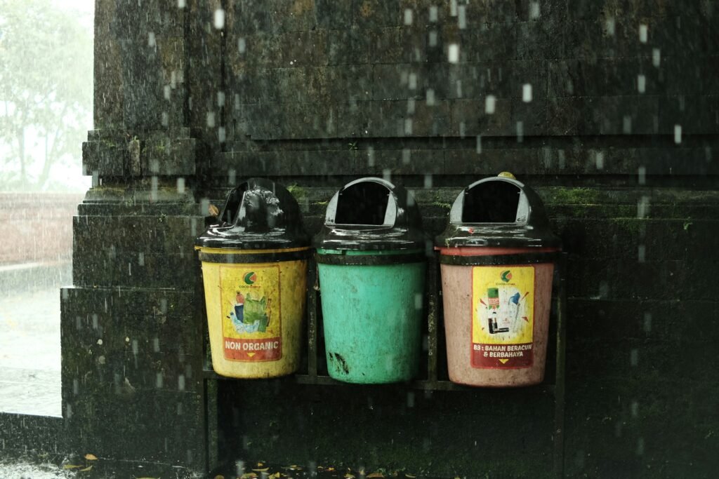 A row of public trash bins in Bali during heavy rain, highlighting the island’s waste management and disposal challenges.
