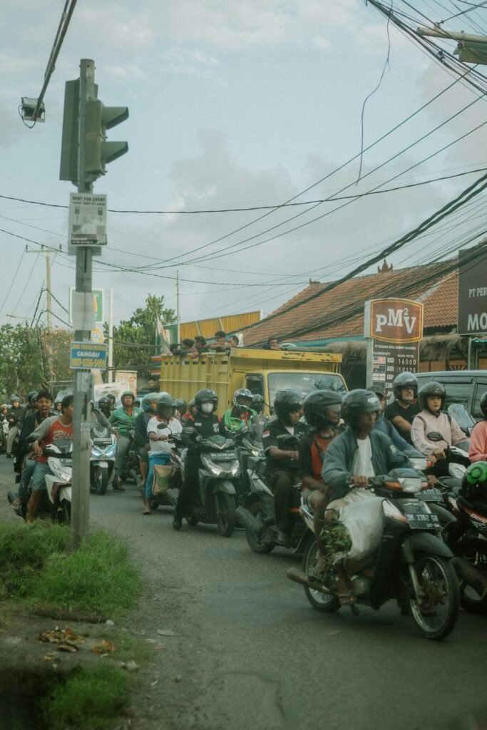 Heavy scooter and car traffic on a congested road in Bali, Indonesia.
