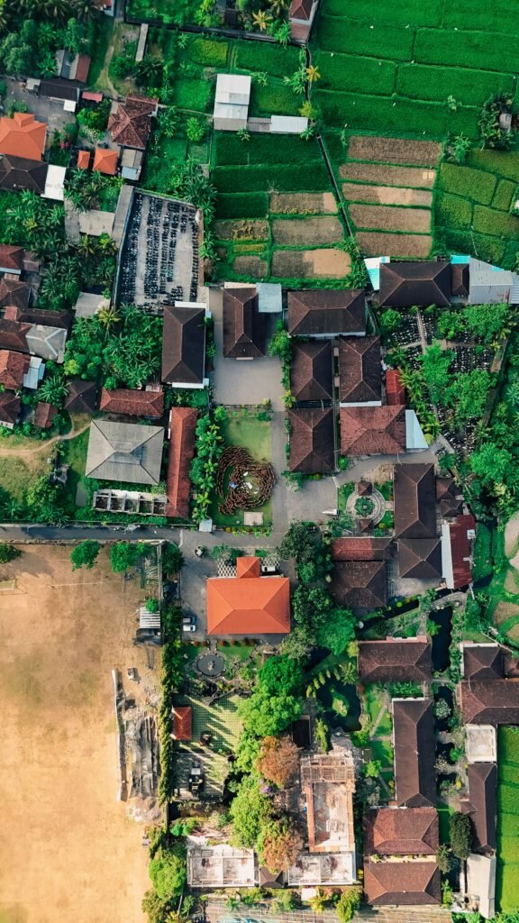 Aerial view of rice fields being surrounded by buildings and development in Bali, Indonesia.