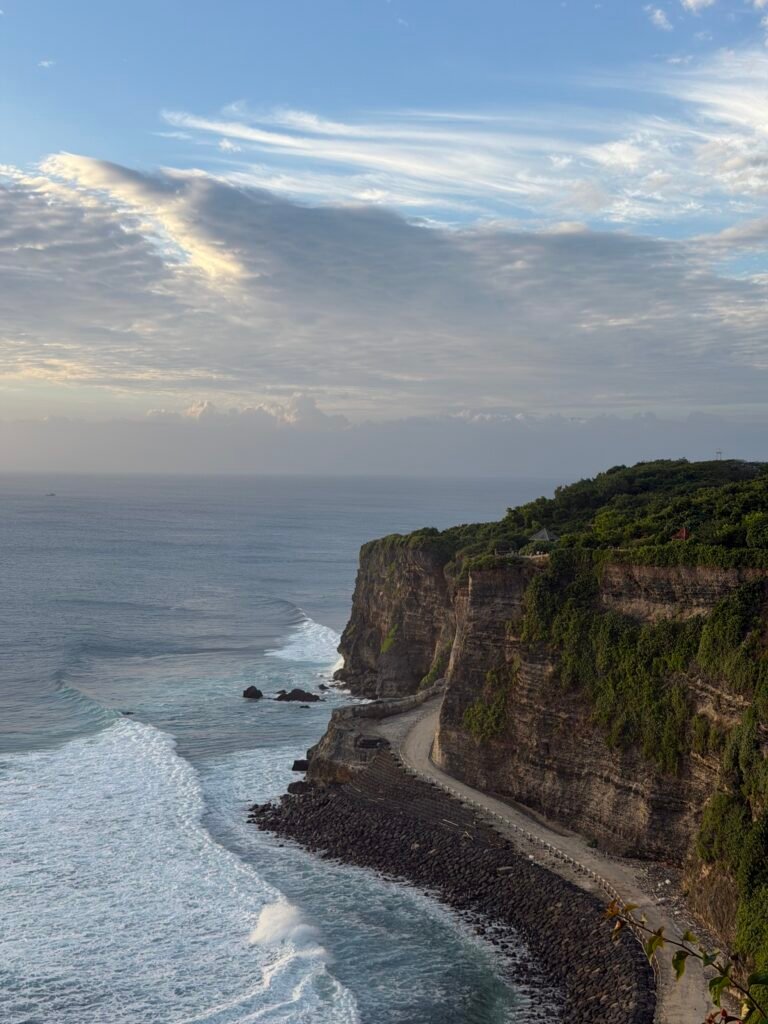 Dramatic limestone cliffs and ocean waves along the coast of Uluwatu, Bali.